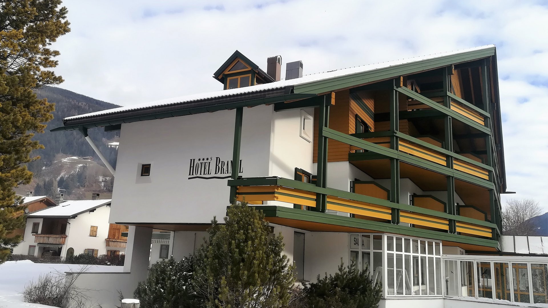 Hotel Brandl in Innichen Hotel Bräuwirt im Winter mit Schnee und Bergen im Hintergrund